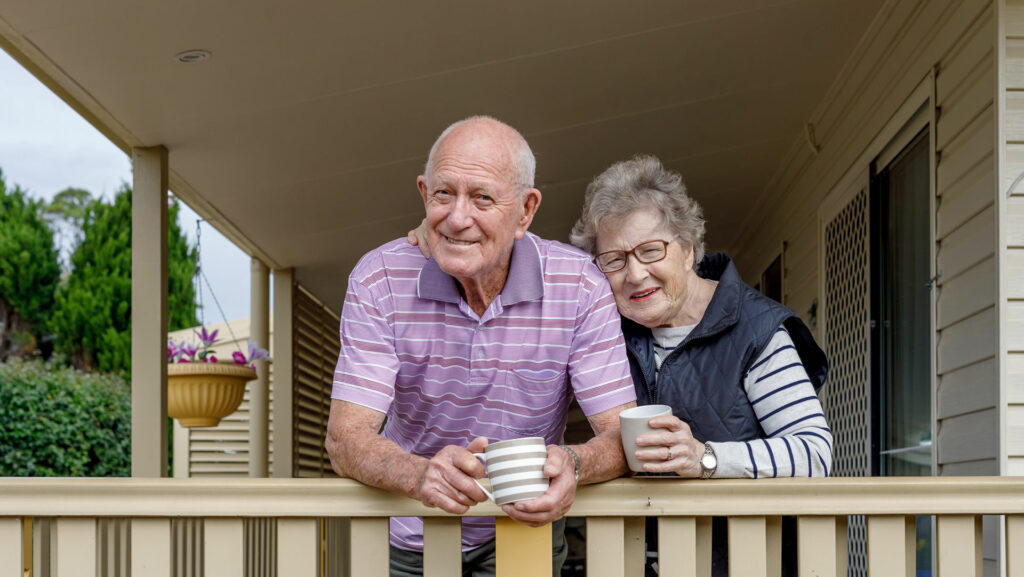 mature adults standing on their porch