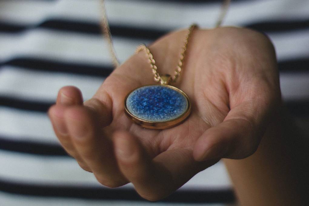 hand holding a necklace, which is a family heirloom